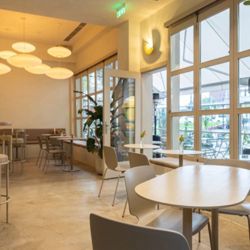 Λεπτομέρεια της μεταλλικής δομής που υποστηρίζει τα φωτιστικά και τοποθετείται αρμονικά πάνω στο μέτωπο του καταστήματος, αποτυπώνοντας την τεχνική αρτιότητα και το μοντέρνο industrial ύφος.